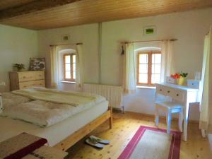 a bedroom with a bed and a desk and windows at Ferienhaus Baumgarten1 in Gnas