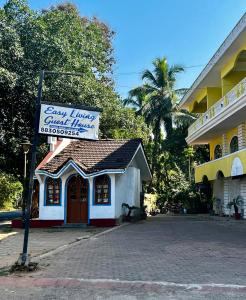 a small building with a sign in front of a building at Easy Living Guesthouse in Varca