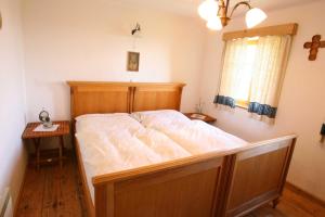- un grand lit dans une chambre avec un cadre en bois dans l'établissement Kellerstöckl Leitner, à Strem
