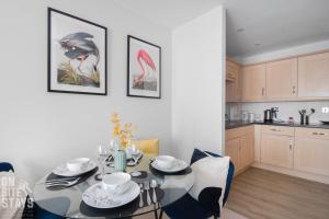 a dining room with a table and a kitchen at OnSiteStays 2BR, Parking, Wifi, Shops and Restaurants Close in Hatfield