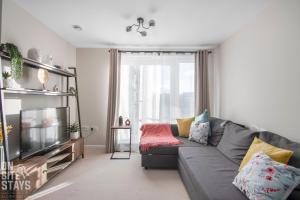 哈特菲尔德OnSiteStays 2BR, Parking, Wifi, Shops and Restaurants Close的客厅配有灰色的沙发和电视