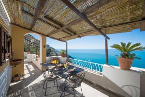 a balcony with a table and chairs and the ocean at Elegant house overlooking the sea, easy park, wifi in Praiano