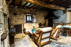 uma sala de estar com paredes de pedra e uma mesa e cadeiras em Casona de El Castañíu em Serrapio