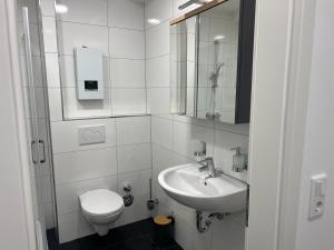 Baño blanco con aseo y lavamanos en RUEHOME, en Essen