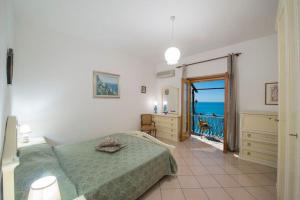 a bedroom with a bed and a balcony with the ocean at Elegant house overlooking the sea, easy park, wifi in Praiano