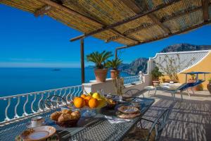 a table with food on a balcony with a view of the ocean at Elegant house overlooking the sea, easy park, wifi in Praiano
