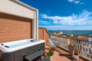 a hot tub on a balcony with a view of the ocean at Archinuè in Siracusa