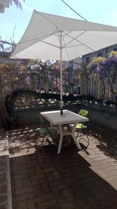 a white picnic table with an umbrella on a patio at Stanza indipendente a Gallarate in Gallarate