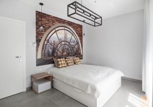 1 dormitorio con cama y pared de ladrillo en Landmark Apartments, en Cracovia