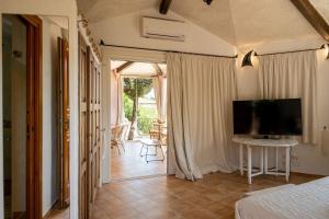 a bedroom with a bed and a television in a room at [CALA DI VOLPE] Vista Mare e Piscina in Abbiadori