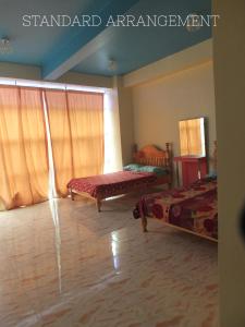 ein Wohnzimmer mit 2 Betten und einem Fenster in der Unterkunft YahVilla Homestay in Baguio City