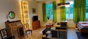 ein Wohnzimmer mit grünen Vorhängen und einem Sofa in der Unterkunft zentrumsnahes Wohnen in der Alten Schule am See in Schwerin