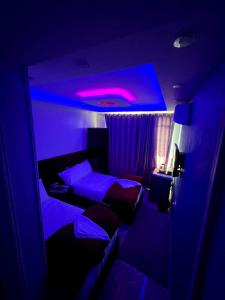 a dark room with a bed and a purple light at pyramids stone Top in Cairo