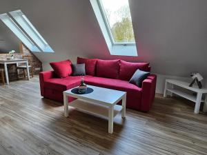 sala de estar con sofá rojo y mesa en Loft- Privatzimmer 30qm im Dachgeschoss mit eigenem Bad, en Ahaus