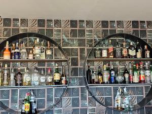 a wall with two circular shelves with bottles of alcohol at Hotel Arcadia in None