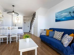 een woonkamer met een blauwe bank en een tafel bij 394 Renovated Duplex Parque Santiago II in Playa de las Americas