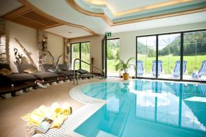 einen Pool in einem Haus mit einem Wohnzimmer in der Unterkunft Chasa Castello relax & spa in Samnaun