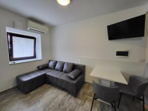 a living room with a couch and a table at Studio Morsal in Koper
