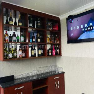 a bar with a bunch of bottles of alcohol at Rosenia Boutique Hotel_Block 3 in Gaborone