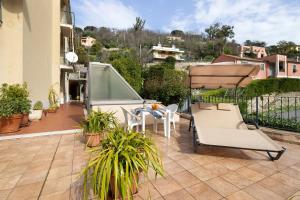 a patio with a table and a bench on a balcony at Il giardino di Giò in Finale Ligure