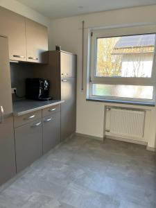 a kitchen with a refrigerator and a window at Ferien bzw Messewohnung in Sinzheim bei Baden Baden in Sinzheim