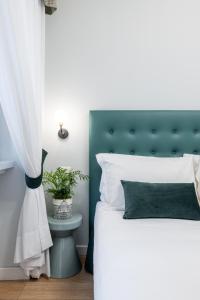 una camera con letto bianco e testiera verde di Domus Bella Roma a Roma