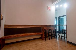 a bar with a wooden bench and stools at Hotel O Hi Inn 3 in Sibu