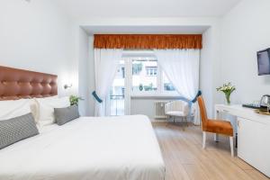 ローマにあるDomus Bella Romaのベッドルーム1室(白いベッド1台、デスク、窓付)