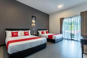 ein Hotelzimmer mit 2 Betten und einem Fenster in der Unterkunft OYO 90149 Pua Family Semporna in Semporna