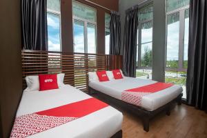 2 camas en una habitación con ventanas en OYO 90094 Hi Inn 3, en Sibu