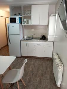 a kitchen with white cabinets and a white refrigerator at MORENO in San Carlos de Bariloche
