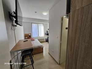 a room with a kitchen with a table and a bed at Studios Immostrasbourg - hébergements de tourisme classés proche centre et Conseil d'Europe in Strasbourg