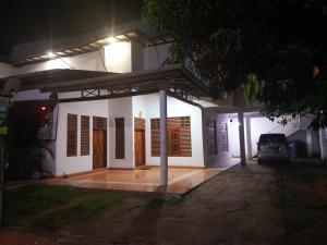 ein weißes Haus mit einer Veranda in der Nacht in der Unterkunft Happy Resort Yala in Tissamaharama