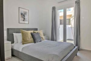 a bedroom with a large bed with a window at Phaedrus Living: Luxury Residence Faneromeni in Larnaca