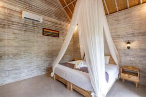 - une chambre avec un lit et une moustiquaire dans l'établissement Le Biu garden View, à Nusa Lembongan