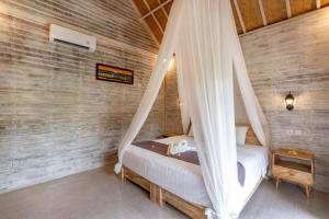 1 dormitorio con 1 cama con mosquitera en Le Biu garden View, en Nusa Lembongan