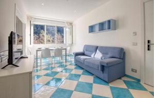 a living room with a blue couch and a kitchen at Lovely Apartment In Deiva Marina in Deiva Marina +18 photos