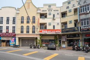 a city street with motorcycles parked in front of buildings at OYO 1194 Best Stay Hotel Pangkor in Pangkor