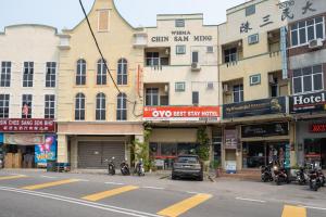 eine Stadtstraße mit Motorrädern vor den Gebäuden in der Unterkunft OYO 1194 Best Stay Hotel Pangkor in Pulau Pangkor