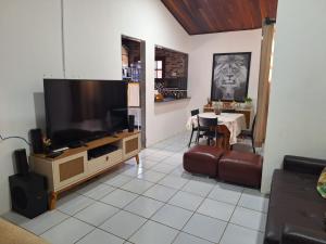 een woonkamer met een grote televisie en een tafel bij Casa de campo em Gravatá in Gravatá