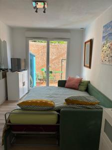 een slaapkamer met een bed, een bank en een raam bij Studio jardin 5 mn plage Monaco Air Conditioner in Beausoleil