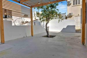 a courtyard with a tree in front of a building at Phaedrus Living: Luxury Residence Faneromeni in Larnaca