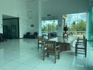 una sala da pranzo con sedie, tavolo e finestre di OYO 90934 Tong Villion Hotel a Muadzam Shah
