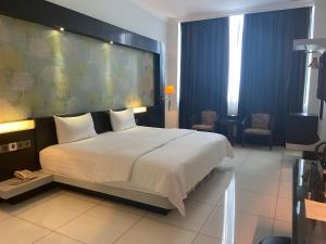 sypialnia z dużym łóżkiem z dużym zagłówkiem w obiekcie OYO 90934 Tong Villion Hotel w mieście Muadzam Shah