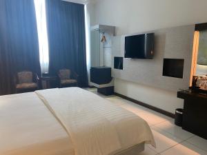 una camera con letto e TV a schermo piatto di OYO 90934 Tong Villion Hotel a Muadzam Shah