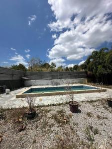 巴東馬士力的住宿－OYO 90938 The Nk Langkawi，院子里有两株盆栽植物的游泳池