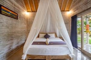 een bed met een klamboe in een kamer bij Le Biu garden View in Nusa Lembongan