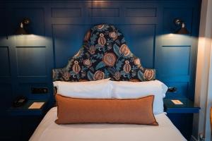 Dormitorio azul con cama con cabecero en McGrory's Hotel, en Culdaff