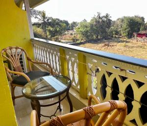 a balcony with a table and chairs and a window at Easy Living Guesthouse - Close to Margao, near Varca Beach, Varca in Varca