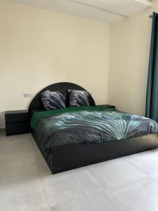 a bed with a black bed frame in a room at Ultra Moderne appart centre Ville in Lomé